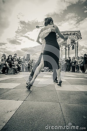 Cuenca, Ecuador - April 22, 2015: Couple performing latin dance styles on city square in front of small crowd, black and white edi Editorial Stock Photo