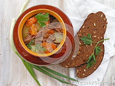 Cuisine of Belarus, russian traditional cuisine : Stewed rabbit with vegetables Goulash in Copper Pot on Wooden shabby Surface, ro Stock Photo