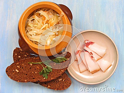 Cuisine of Belarus, traditional russian cuisine Sauerkraut in a ceramic barrel pot with break on blue shabby background Stock Photo