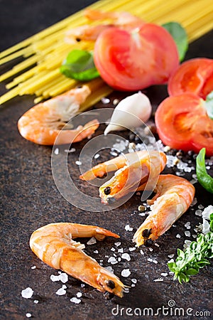 Culinary background for cooking with pasta, shrimps, tomatoes, fresh herbs and spices Stock Photo