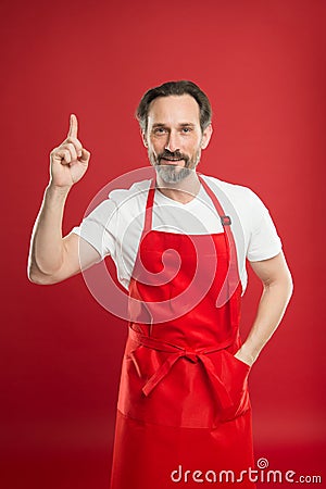 Culinary magic. Cook with beard and mustache wearing apron red background. Man mature cook posing cooking apron. Chief Stock Photo