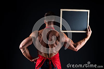 Culinary school information. Cook hold information board in strong hand back view. Muscular man with blank blackboard on Stock Photo