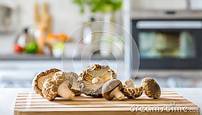 A selection of fresh vegetable: maitake mushroom, sitting on a chopping board against blurred kitchen background copy space Stock Photo