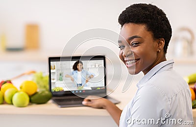 Culinary Workshop. Smiling Black Woman Having Online Cooking Lesson With Professional Cook Stock Photo