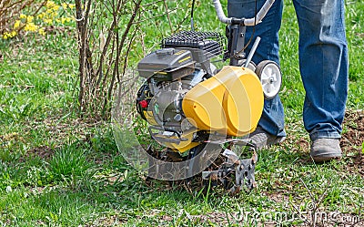 Cultivator for tillage in the garden,motor cultivator. Man Farmer plows the land with a cultivator Stock Photo