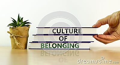 Culture of belonging symbol. Books with words `culture of belonging` on beautiful white background. Businessman hand. Business, Stock Photo