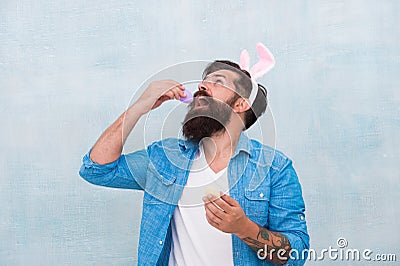 Culture customs and traditions. Easter bunny colored eggs. Celebration of spring holiday. Bearded man bunny ears and Stock Photo