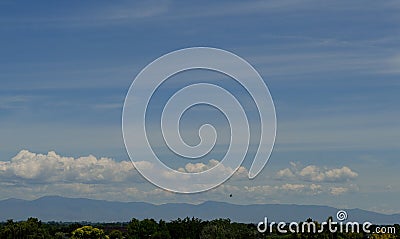 Cumulus cirrus clouds hawk in flight hazy day Idaho Stock Photo