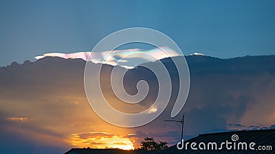 Cumulus sunset clouds with sun setting down Stock Photo