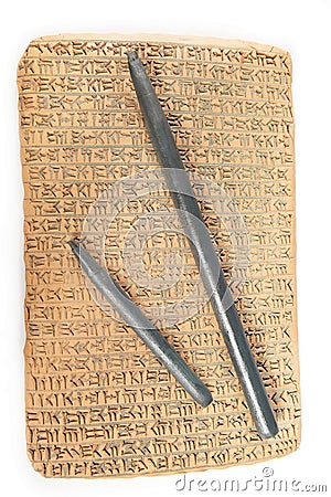 Cuneiform written in brown clay with rest of sand dirt and wooden writing tools Stock Photo