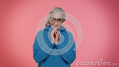 Cunning mature grandmother woman thinking over devious villain idea, cunning cheats jokes and pranks Stock Photo