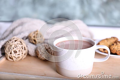 Cup of aromatic cacao on wooden tray near window Stock Photo