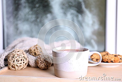 Cup of aromatic cacao on wooden tray near window Stock Photo