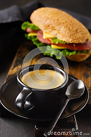 Cup of aromatic coffee and healthy sandwiches with bran bread, cheese, lettuce, tomato and sliced salami and glass of freshly sque Stock Photo