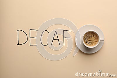 Cup of aromatic coffee and word Decaf on beige background Stock Photo