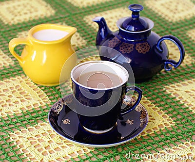 Cup of beverage. jug and teapot on back plane Stock Photo