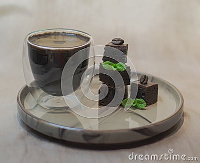 Cup of black coffee with pieces of brownie. Stock Photo