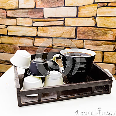 A cup of black coffee with capsules for coffeemachine on stone b Stock Photo