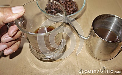 A cup of black coffee filled from the Turkish pot coffee Stock Photo