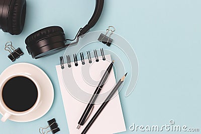 Cup of black coffee, headphones, notepad and stationery. Stock Photo
