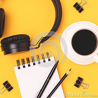 Cup of black coffee, headphones, notepad and stationery. Stock Photo