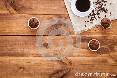 Cup of black coffee, muffins and coffe beans scattered on brown wooden table, cofee cafe cafeteria shop background, hot drink in Stock Photo