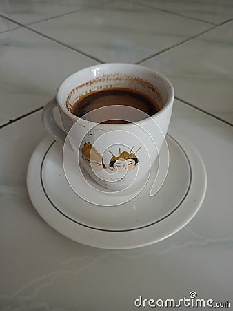 a cup of black coffee typical of Bogor Indonesia with a picture of a pair of Javanese traditional brides Stock Photo