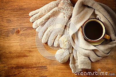 Cup of black coffee with a warm scarf on wooden background. filreted image Stock Photo