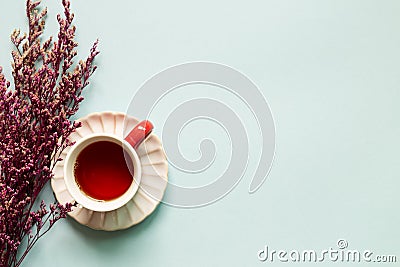 Cup of black tea with pink misty blue dry flowers on sky blue background Stock Photo