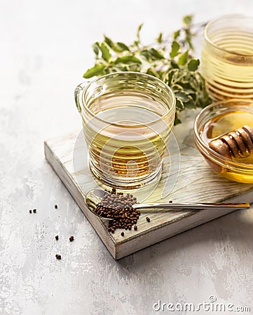 Cup with buckwheat tea, granules and honey, light grey background. Superfood Taiwan Ku Qiao buckwheat tea and grits of tartary Stock Photo