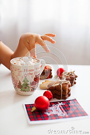 A cup with cacao and marshmallow and childs hand, side view Stock Photo