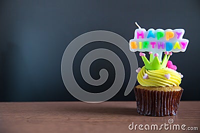 Cup cake and happy birthday text candle on cupcake ..Birthday cupcake with a happy brithday text candle. Stock Photo