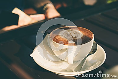 Cup of cappuccino with cinnamon on a wooden table in a cafe Stock Photo