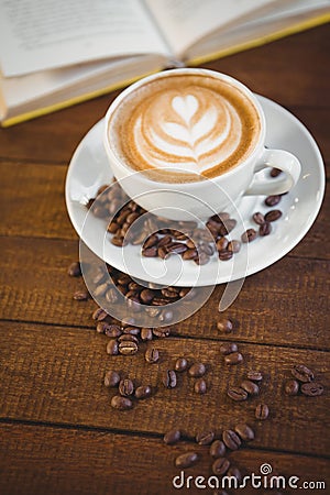 Cup of cappuccino with coffee art and coffee beans Stock Photo