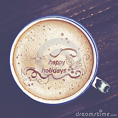 Cup of cappuccino coffee on wooden table. Words happy holidays f Stock Photo