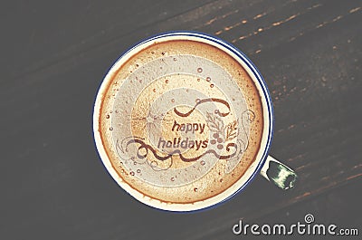 Cup of cappuccino coffee on wooden table. Words happy holidays f Stock Photo