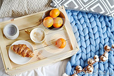 Cup with cappuccino, croissant, blue pastel giant plaid, bedroom, morning concept Stock Photo