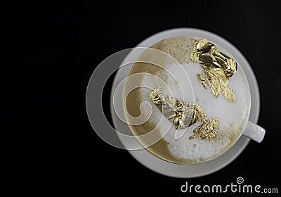 Cup of cappuccino with a golden foam, luxury drink concept. Stock Photo