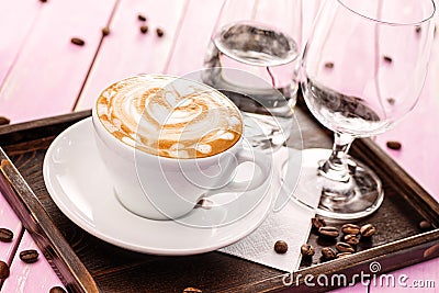 Cup of cappuccino with heart foam, set of cup of coffee with coffee beans on pink wooden background, drink hot product photography Stock Photo