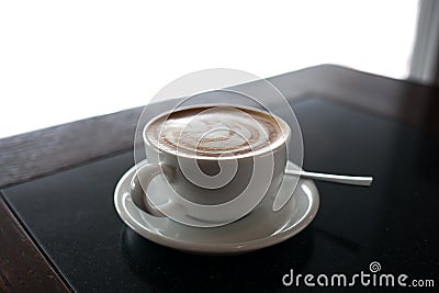 Cup of cappuccino with latte art on black table background. Beautiful foam, place for text. Stock Photo