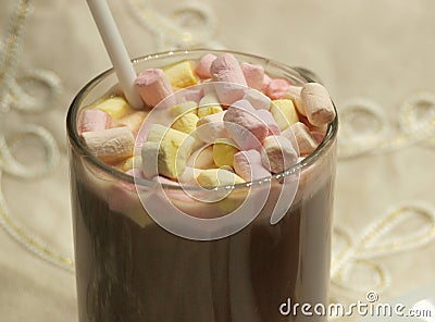 Cup with cocoa, straw and colored marshmallows on a beige tablecloth background Stock Photo