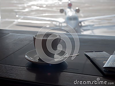 Cup of coffee in airport`s business lounge with aircraft Stock Photo