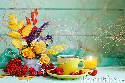 Cup of coffee, autumn leaves and flowers on a wooden table. Autumn still life. Selective focus. Stock Photo