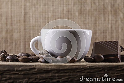 Cup, coffee beans, chocolate on a wooden board closeup background Stock Photo