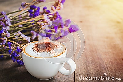 A cup of coffee with bouquet of violet dried flowers on wooden f Stock Photo