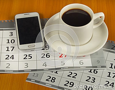 Cup of coffee, cell phone, calendar on wooden table Stock Photo