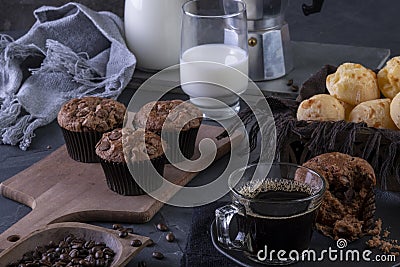 A cup of coffee, chocolate muffins, cheese breads and milk Stock Photo