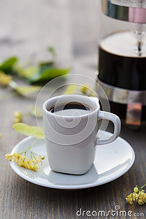 Cup of coffee, coffee pot and linden flower on the table Stock Photo