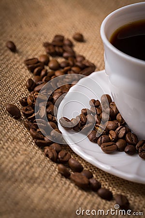 Cup of coffee with coffeebeans on linen material. Stock Photo