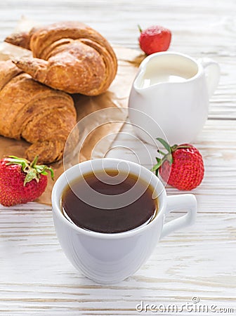 Cup of coffee, croissants, strawberry and milk jar Stock Photo